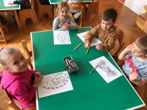 Dzieci z grupy Wiewiórki siedzą przy stoliku i kolorują kolorowanki z ulubionych bajek.